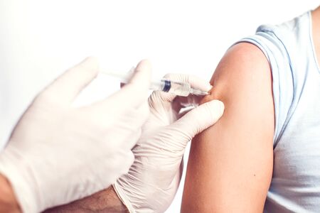 A doctor doing injection to the patient. Isolated. Close up shot. Medicine and healthcare conceptの写真素材