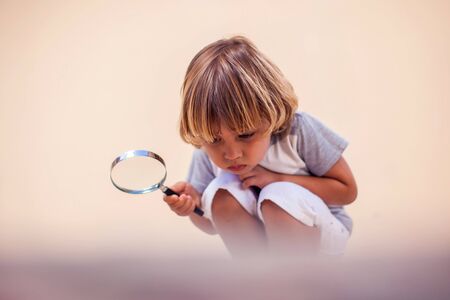 A portrait of kid boy holding magnifier. Childhood and discoveries conceptの写真素材