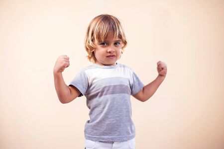 A portrait of kid boy showing strong hands. Children and  health conceptの写真素材