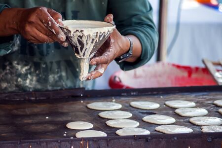 Man cooking tasty pancakes on the street in ramadan time. 
Arabic traditional cuisine
