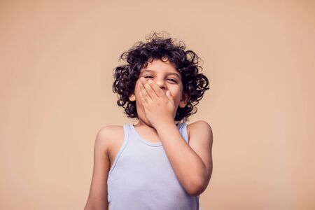 A portrait of surprised kid boy with curly hair. Children and emotions conceptの写真素材
