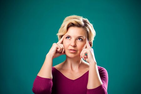 Woman with short blond hair thinking or dreaming. People, lifestyle and emotions conceptの写真素材