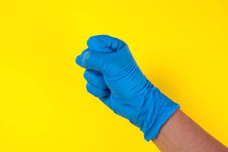 Hands in blue medical gloves showing fist gestures. Medicine and healthcare concept