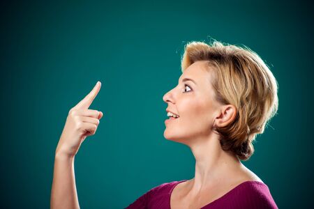 Woman with short blond hair touching her long nose because of lie . People,lifestyle and emotions conceptの写真素材