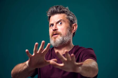 A portrait of scared bearded man in red t-shirt. People and emotions conceptの写真素材