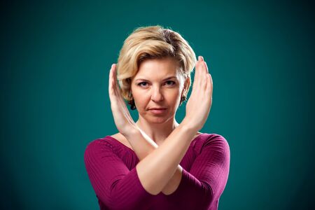 Angry woman with short blond hair showing stop gesture. People, lifestyle and emotions conceptの写真素材