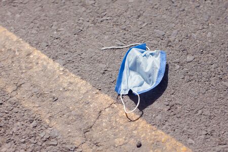 Used medical face mask on the ground. Garbage and environmental pollution conceptの写真素材