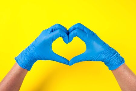 Hands in blue medical gloves showing heart gesture. Medicine and healthcare conceptの写真素材