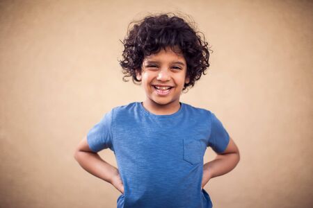 A portrait of happy kid boy with curly hair. Children and emotions konceptの写真素材