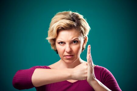 Angry woman with short blond hair showing fists at camera. People, lifestyle and emotions conceptの写真素材