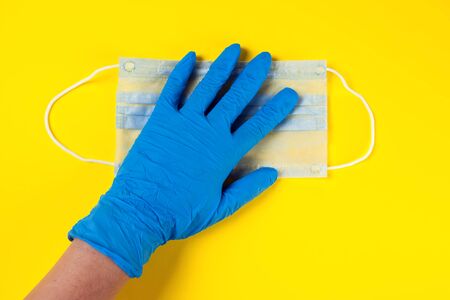 Hands in blue medical gloves holding face mask. Medicine and healthcare concept