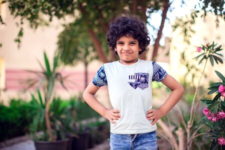 A portrait of smiling kid boy with curly hair outdoor. Children and emotions conceptの写真素材