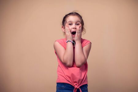 A portrait of surprised cute kid girl. Children and emotions concept
