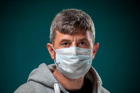 A portrait of man with medical face mask. People, medicine and healthcare concept. Coronavirus protectionの写真素材