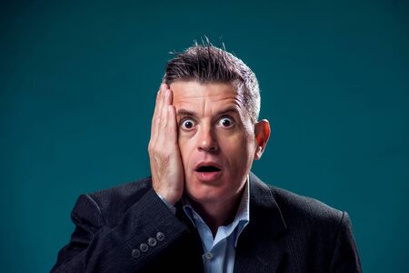 A portrait of surprised or shocked businessman in suit. People and emotions conceptの写真素材