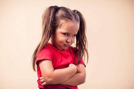 A portrait of kid girl showing sad expression. Children and emotions concept