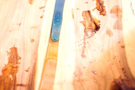 Treatment of wood with blue epoxy and varnish. Manufacturing of futniture from solid.の写真素材