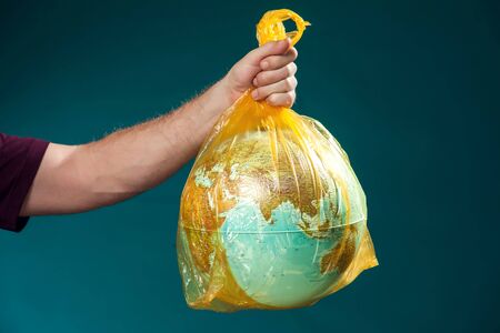 A man holding globe in plastic bag. Earth pollution and environment pritection concept. Studio shot