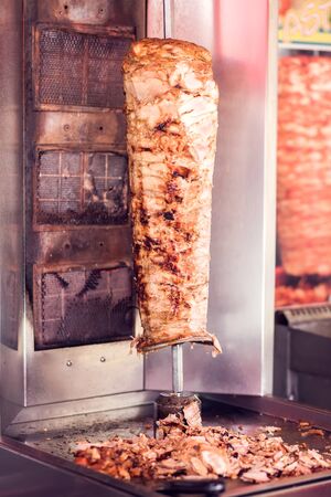 A cook cutting kebab meat with knife at fast food cafeの写真素材