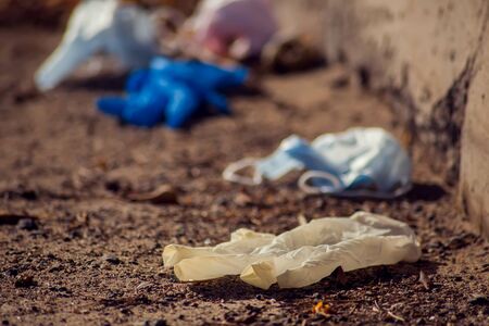Used medical face masks and gloves on the street. Environmental pollution conceptの写真素材