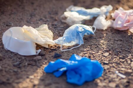 Used dirty medical masks and gloves on ground on the street. Environmental pollution conceptの写真素材