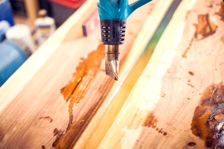Treatment of wood with blue epoxy and varnish. Manufacturing of futniture from solid.