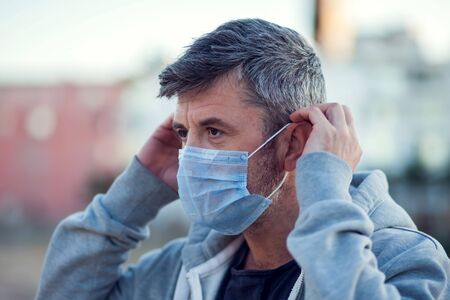 A portrait of man with medical face mask outdoor. People, healthcare and virus protection conceptの写真素材