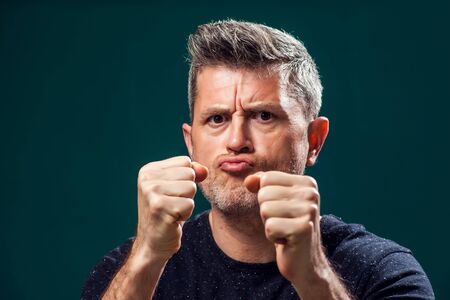 A portrait of angry man showing fists at camera. People and negative emotions concept