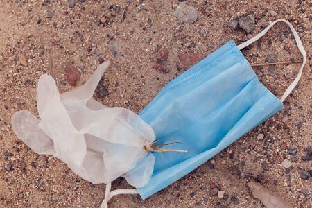 Used dirty medical masks and gloves on ground on the street. Environmental pollution concept