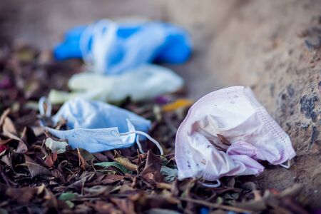 Used medical face masks and gloves on the street. Environmental pollution conceptの写真素材