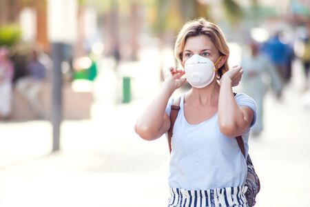A portrait of woman with face medical mask on the street. Virus protection conceptの写真素材