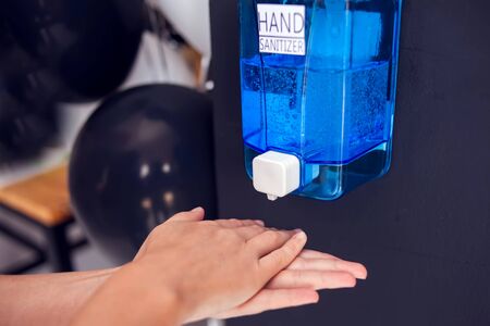 Woman using hand sanitizer in cafe. People and healthcare conceptの写真素材