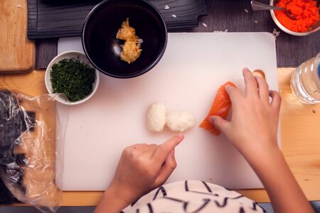 Children making sushi at the master class. Children, education and entertainment concept.の写真素材