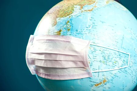 Medicine face mask on the globus. World epidemic of coronavirus concept.
