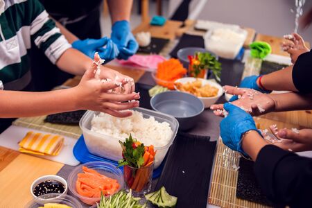 Children making sushi at the master class. Children, education and entertainment concept.の写真素材