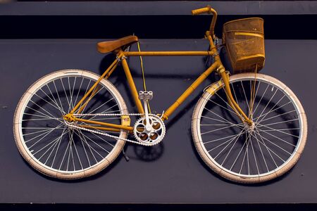 Vintage bicycle hanging on the black wall as an element of designの写真素材