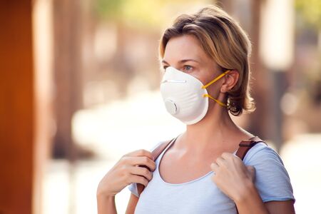 A portrait of woman with face medical mask on the street. Virus protection conceptの写真素材