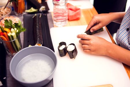 Children making sushi at the master class. Children, education and entertainment concept.の写真素材