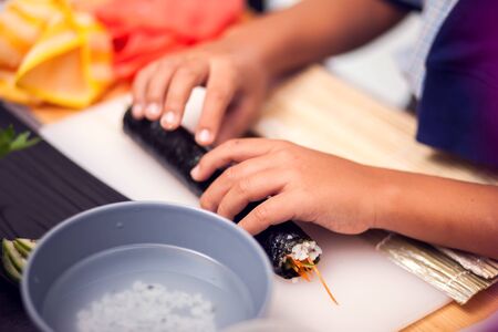 Children making sushi at the master class. Children, education and entertainment concept.の写真素材