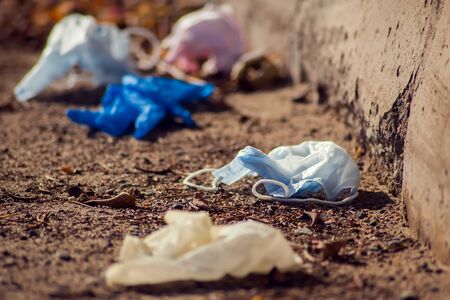 Used medical face masks and gloves on the street. Environmental pollution conceptの写真素材
