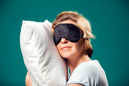 A portrait of sleeping woman with short blond hair and black sleep mask on head. Relaxing timeの写真素材