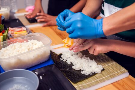 Children making sushi at the master class. Children, education and entertainment concept.の写真素材
