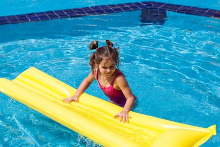 Kid girl playing in the swimming pool. Childhood, summer and holiday concept