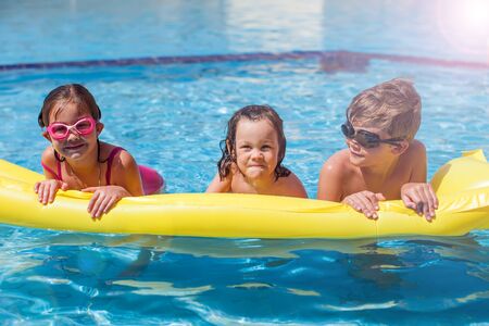 Kids playing in the swimming pool. Childhood, summer and holiday conceptの写真素材