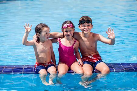 Kids playing in the swimming pool. Childhood, summer and holiday conceptの写真素材