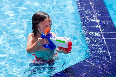 Kid boy playing in the swimming pool. Childhood, summer and holiday conceptの写真素材