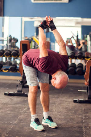 Senior man doing workout before training in the gym. People, healthcare and lifestyle concept