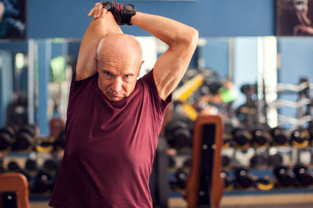 Senior man doing workout before training in the gym. People, healthcare and lifestyle concept