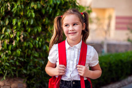 Back to school. Pupil girl with backpack staying outdoorの写真素材