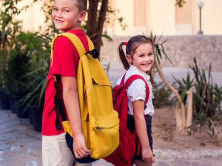 Back to school. Pupils with backpacks staying outdoorの写真素材